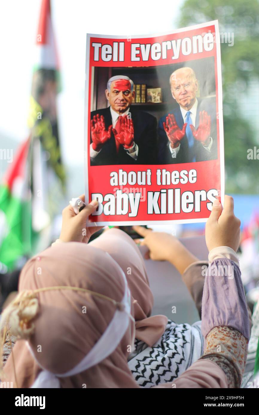 JAKARTA, INDONÉSIE - 1er JUIN : un manifestant pro-palestinien brandit une pancarte indiquant "parlez à tout le monde de ces tueurs de bébés" avec une photo de Joe Biden et Benjamin Netanyahu lors d'une manifestation pro-palestinienne devant l'ambassade américaine à Jakarta, en Indonésie, le 1er juin 2024. La manifestation a protesté contre l'attaque militaire israélienne contre Rafah, Gaza. Banque D'Images
