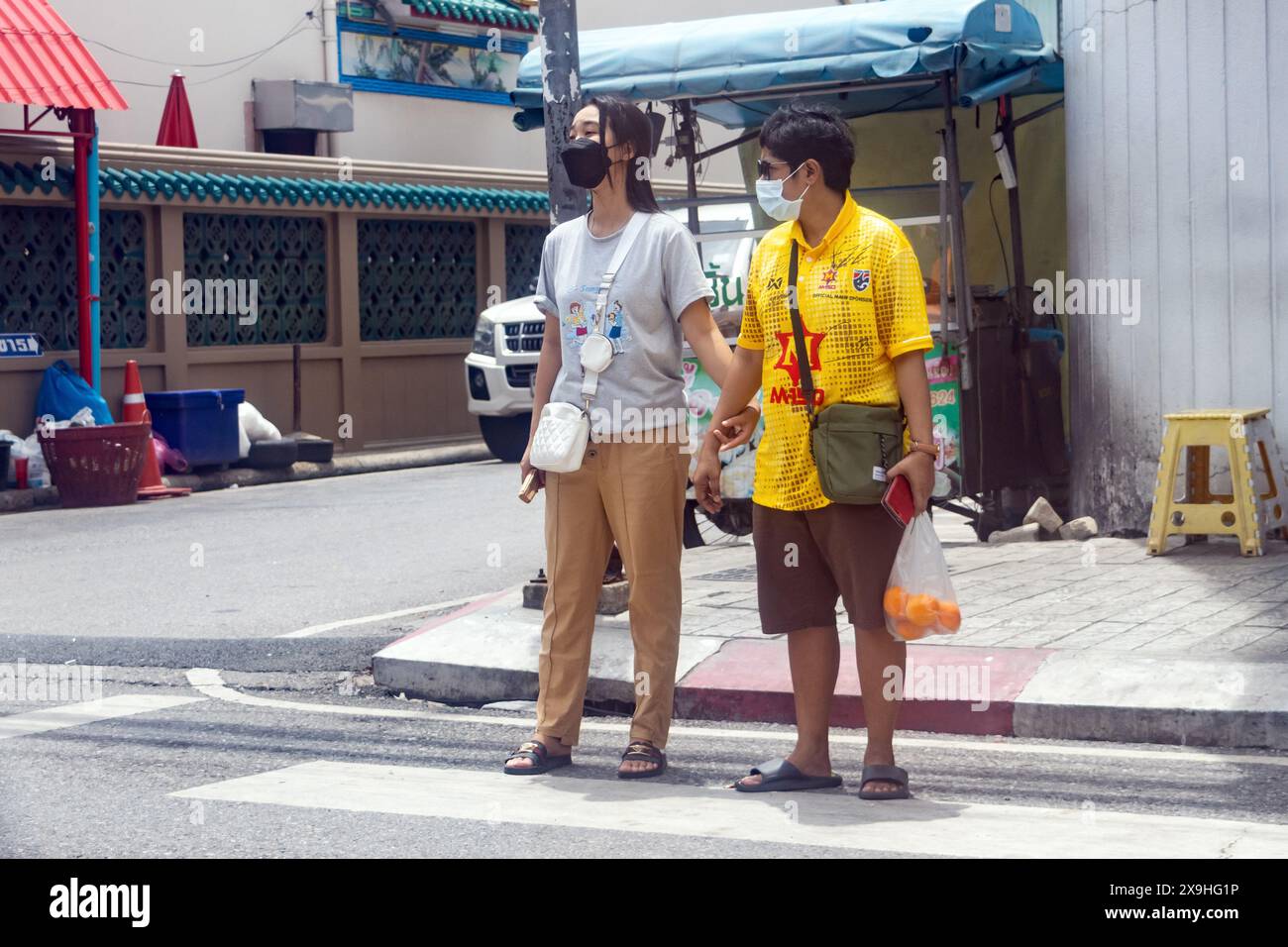 SAMUT PRAKAN, THAÏLANDE, MAI 26 2024, une paire de femmes attend à un passage Banque D'Images