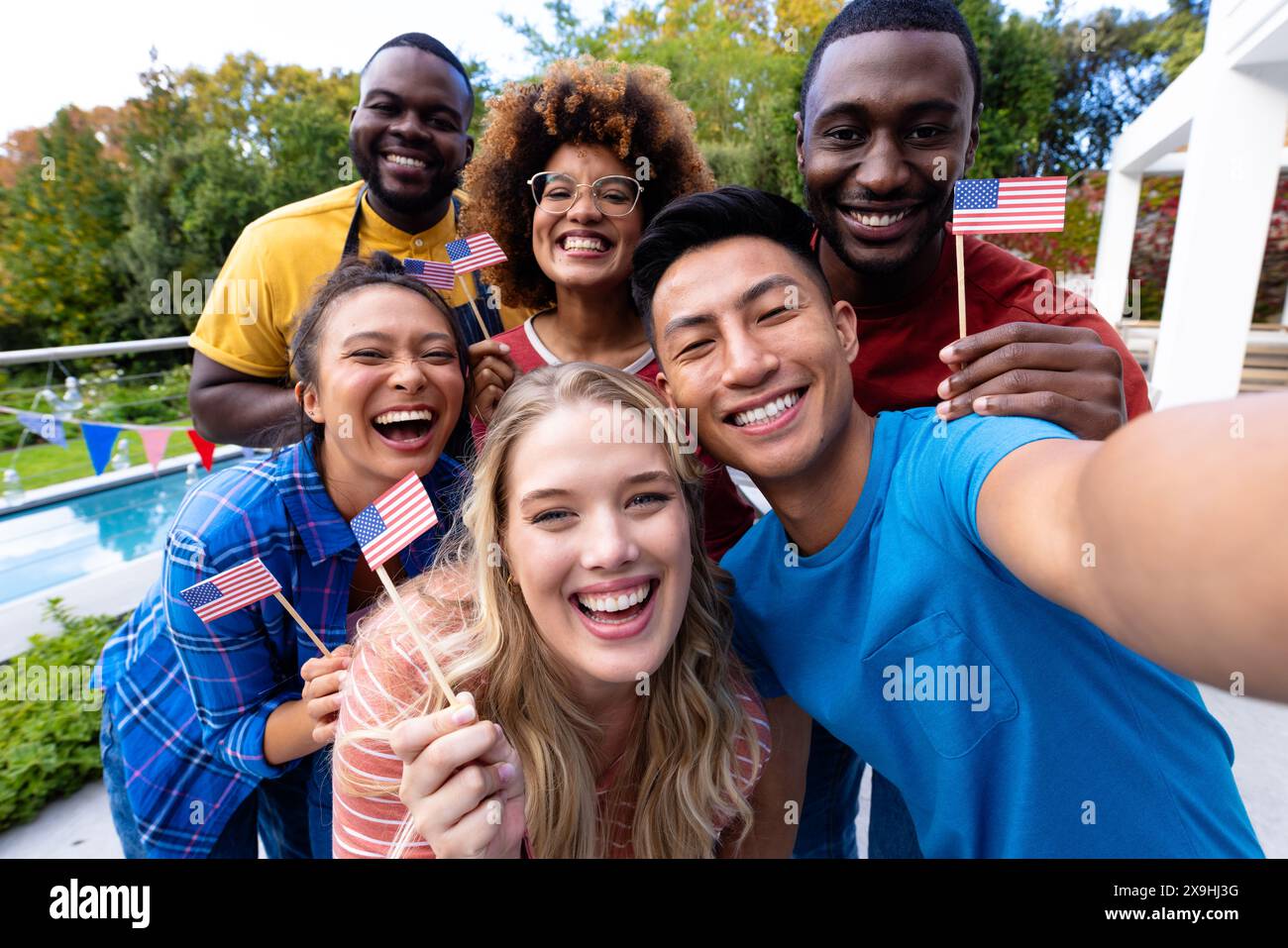 Portrait d'heureux groupe diversifié d'amis prenant selfie et tenant des drapeaux des états-unis Banque D'Images