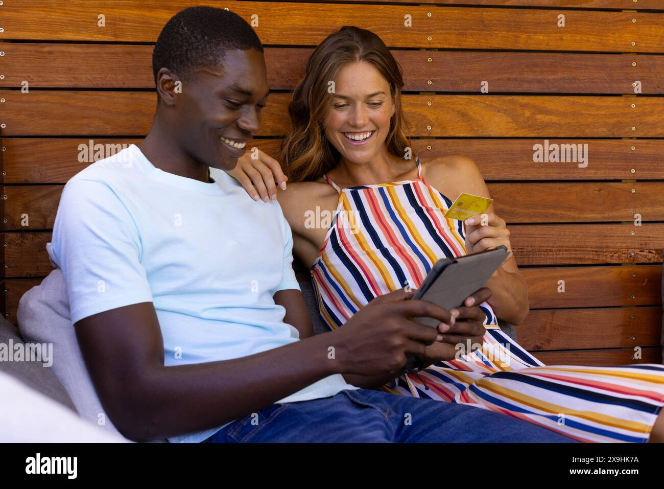 Un jeune couple diversifié à la maison, regardant la tablette ensemble Banque D'Images