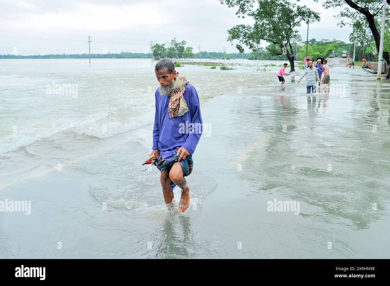 Le cyclone Remal frappe Sylhet des personnes âgées qui luttent pour patauger sur la route principale inondée de Lafnaut, dans la région de Goanghat upazila, en raison des fortes pluies après que le cyclone Remal a frappé le Bangladesh. Le 30 mai 2024 à Sylhet, Bangladesh. Sylhet Sylhet Bangladesh Copyright : xMdxRafayatxHaquexKhanxxEyepixxGrx Banque D'Images