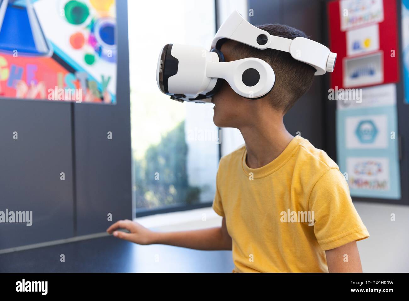 Biracial Boy explore la réalité virtuelle à l'école Banque D'Images