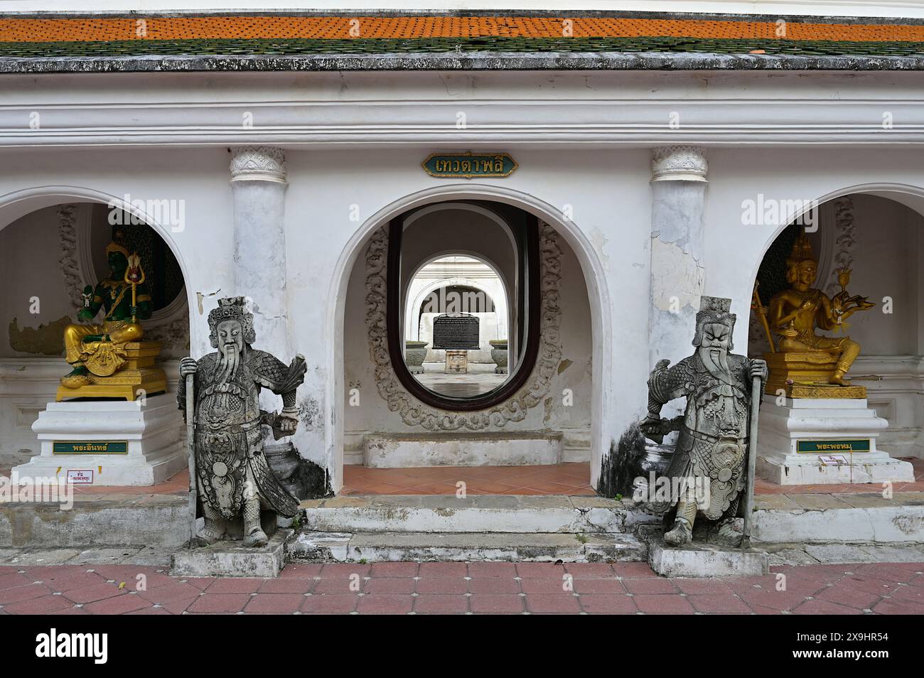 Portail menant à la cour intérieure de Wat Phra Pathommachedi, flanqué d'images de guerriers chinois avec Indra & Brahma à gauche et à droite respectivement Banque D'Images