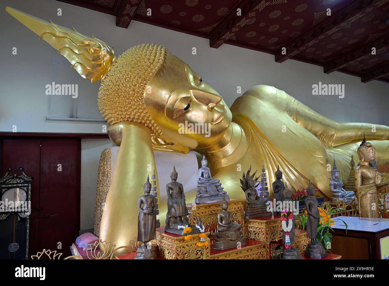 Détail du Bouddha doré couché avec la flamme finial émergeant de l'ushnisha sur le dessus de sa tête, Wat Phra Pathommachedi, Nakhon Pathom, Thaïlande Banque D'Images