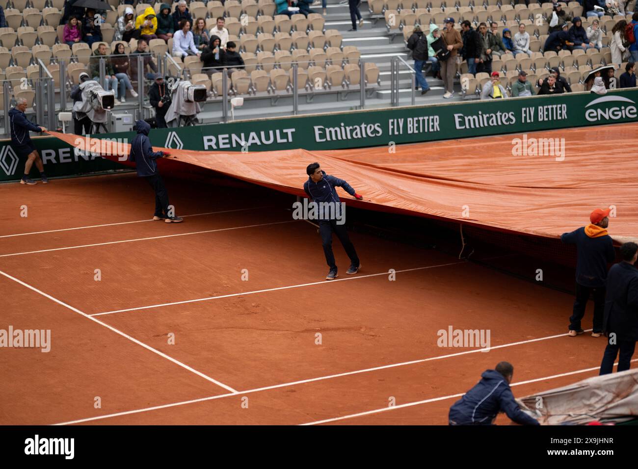 (240601) -- PARIS, 1er juin 2024 (Xinhua) -- le personnel tire sur la couverture de pluie sur le court lors du match de troisième tour féminin en simple à l'Open de France de tennis à Roland Garros à Paris, France, le 1er juin 2024. (Xinhua/Meng Dingbo) Banque D'Images