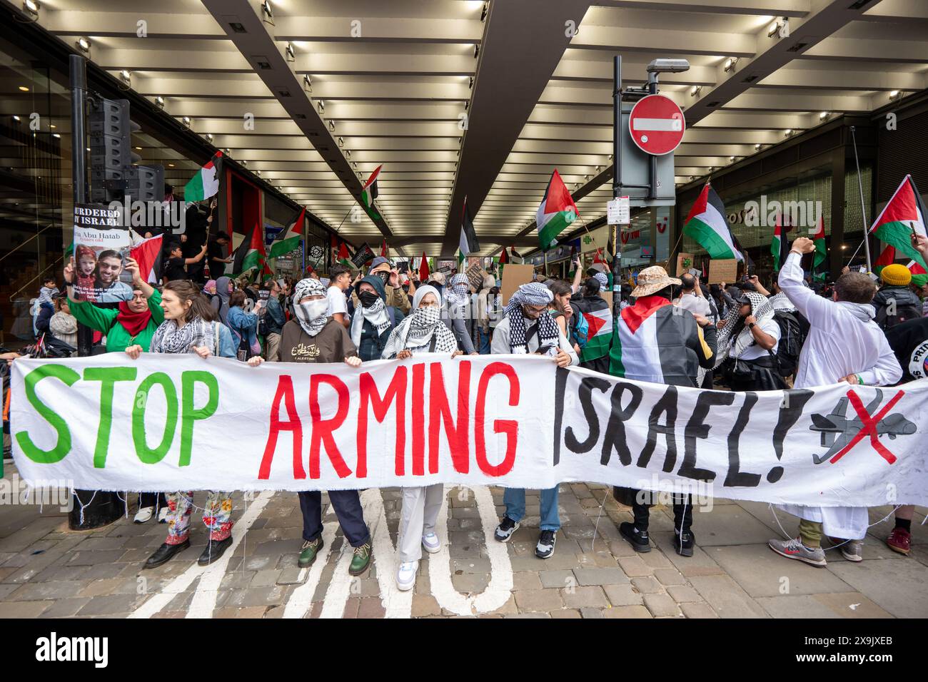 Arrêtez d'armer la bannière israélienne. Manifestation palestinienne dans le centre-ville de Manchester. La manifestation a vu des manifestants passer dans la rue du marché en passant devant une succursale de la Barclays Bank qui a été arraisonnée après que des fenêtres ont été brisées et que le bâtiment était couvert de peinture rouge dans le cadre d'une manifestation contre l'implication des banques dans les investissements en Israël. Manchester, Royaume-Uni photo : Garyroberts/worldwidefeatures.com Banque D'Images