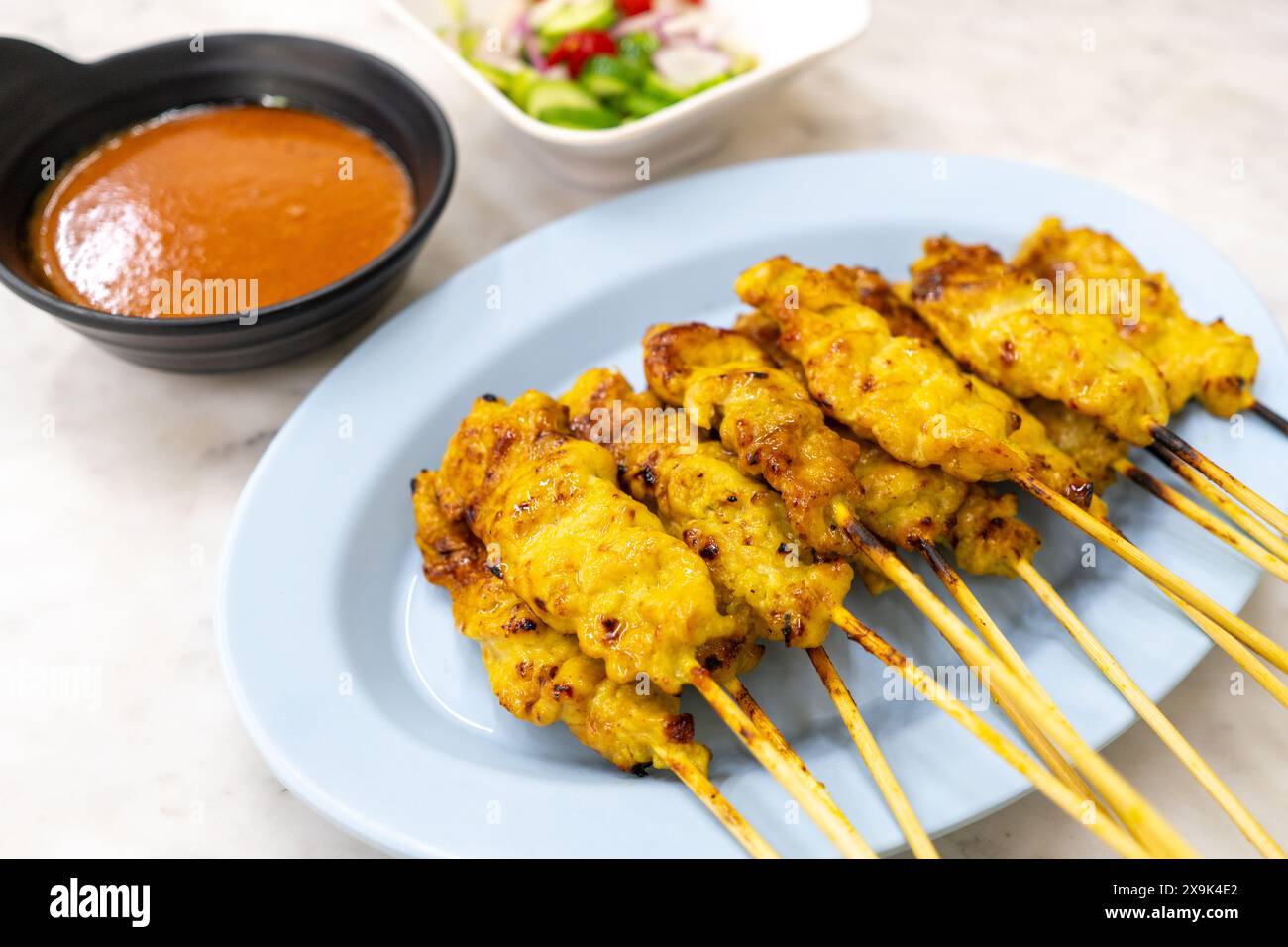 Satay de porc ou porc grillé servi avec de la sauce cacahuète ou de la sauce aigre-douce - cuisine thaïlandaise de style asiatique sur fond blanc. Banque D'Images