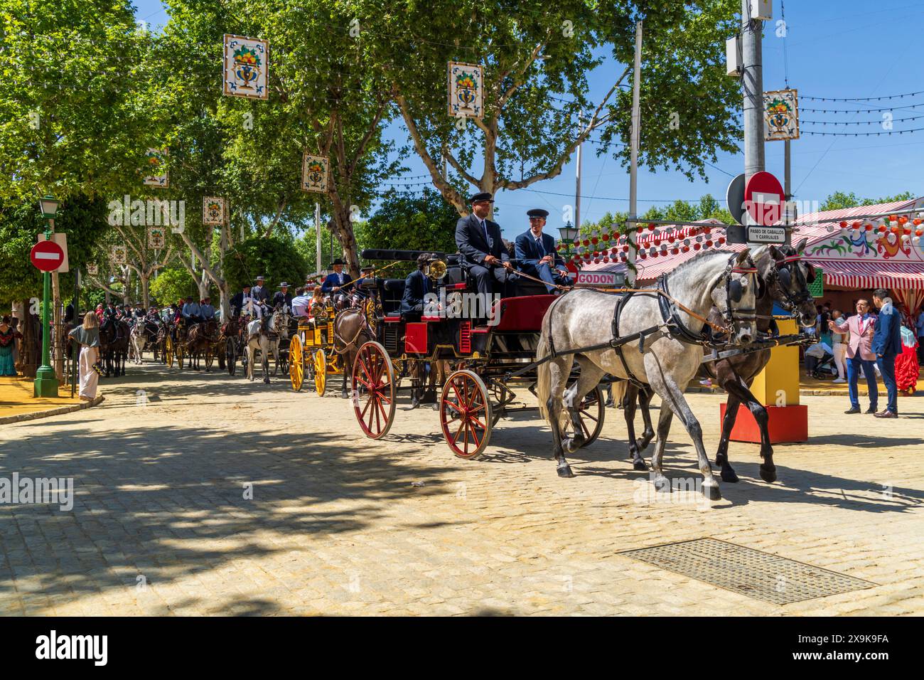 La Foire d'avril de Séville (Feria de Abril de Sevilla ou Foire de Séville) avec des calèches tirées par des chevaux, des tentes de festival colorées et des rues de la ville décorées. Banque D'Images
