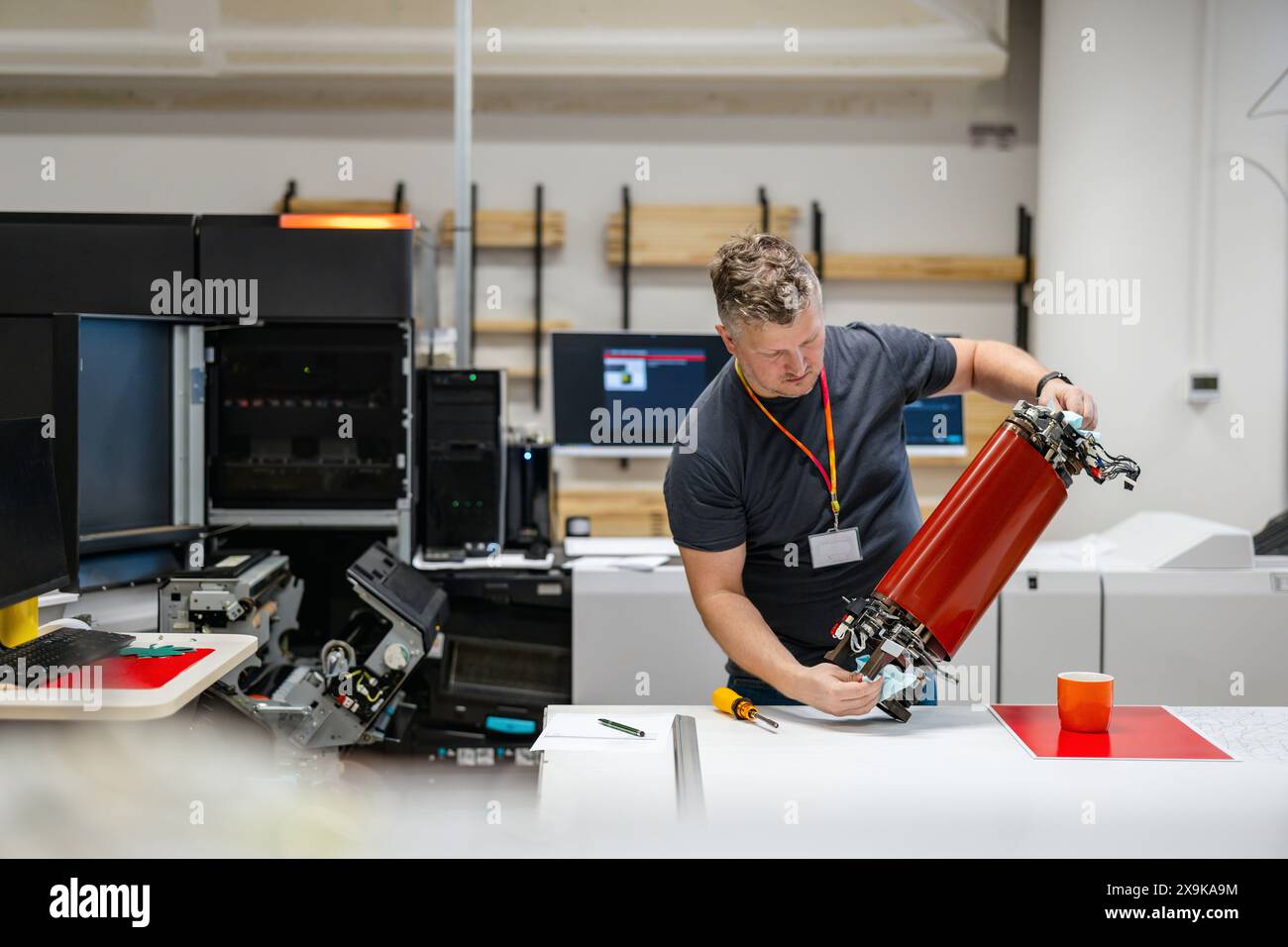 Ingénieur de maintenance dans une machine de fixation de maison d'impression Banque D'Images