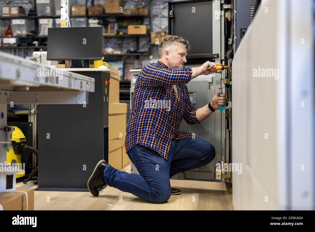 Ingénieur de maintenance dans une machine de fixation de maison d'impression Banque D'Images