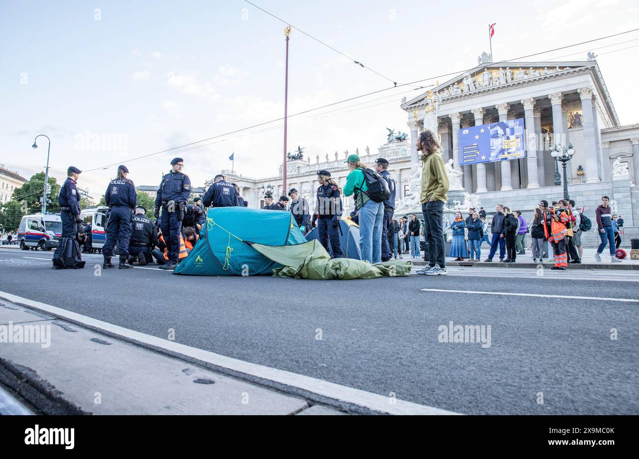 Klimaaktivisten der, Letzten Generation' klebten sich im Zuge einer Protestaktion auf der Ringstraße vor dem Parlament auf die Straße. IM Bild : Polizisten und Klimaaktivisten auf der Ringstraße vor dem Parlament in Wien am 01.06.2024 // les activistes climatiques de l'organisation, dernière génération' se sont retrouvés dans la rue devant le parlement autrichien à Vienne. Photo : forces de police et activistes climatiques devant le Parlement autrichien à Vienne le 1er juin 2024 - 20240601 PD14067 crédit : APA-PictureDesk/Alamy Live News Banque D'Images