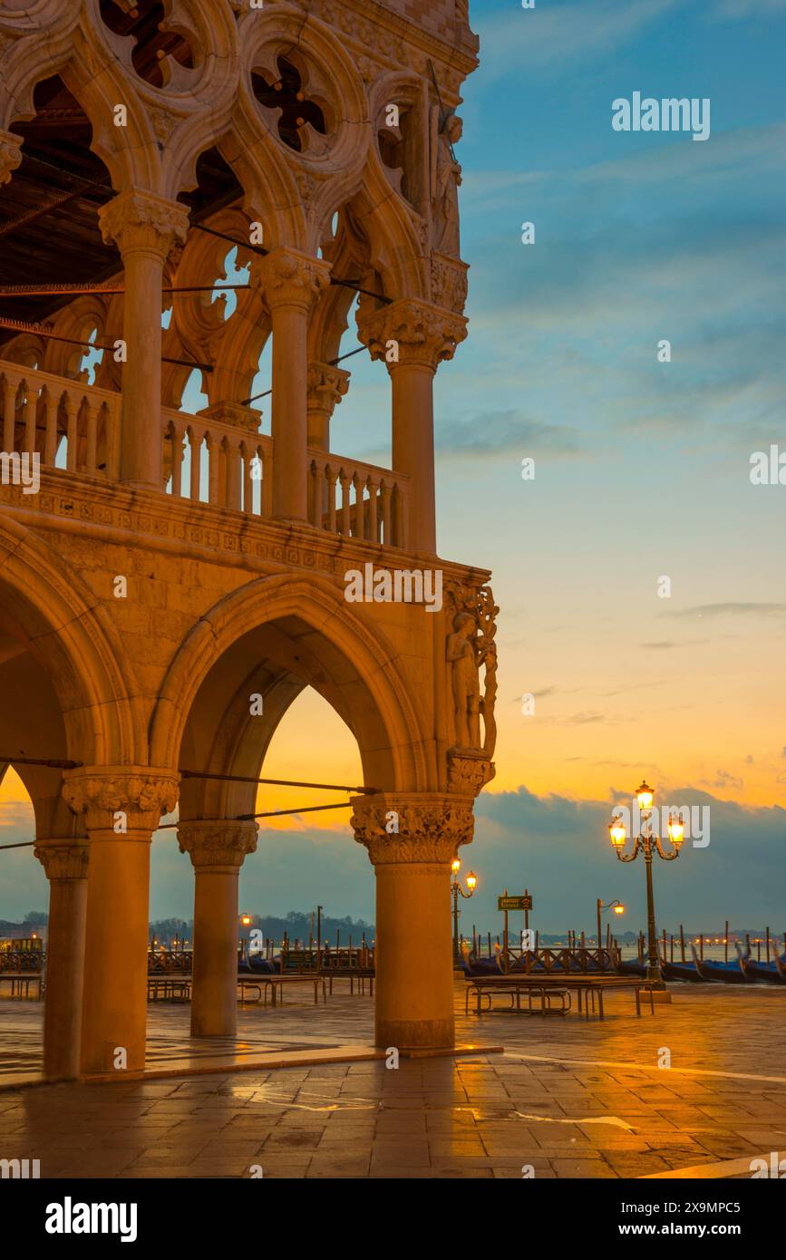 Magnifique Palais Ducal avec des arches et des lampadaires et gondole sur la place San Marco au coucher du soleil à Venise, Vénétie, Italie Banque D'Images