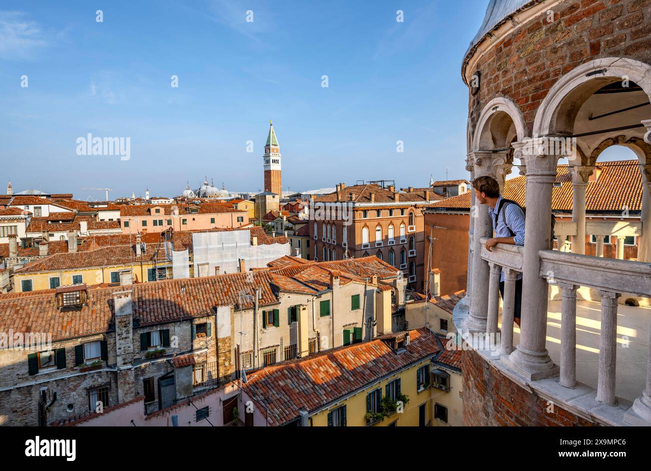 Jeune homme regardant Venise avec campanile, tour du Palazzo Contarini del Bovolo, palais avec escalier en colimaçon, Venise, Vénétie, Italie Banque D'Images
