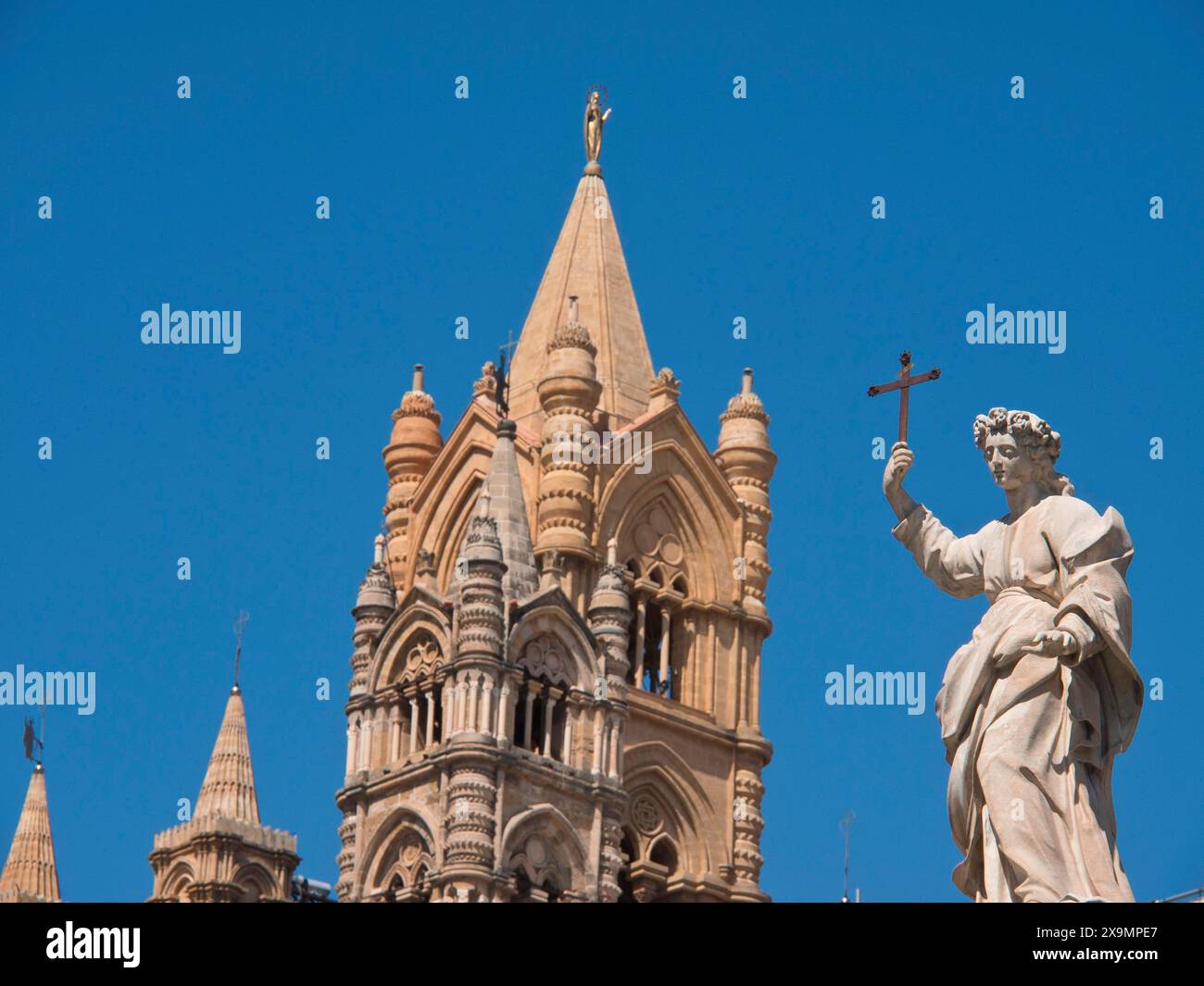 Grand bâtiment de cathédrale avec tour gothique et une statue tenant une croix, palerme en sicile avec une impressionnante cathédrale, des monuments et des maisons anciennes Banque D'Images
