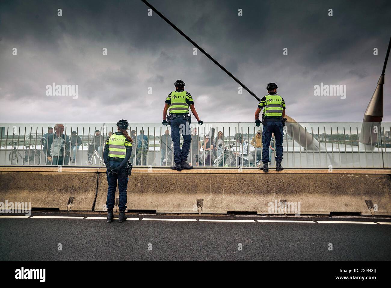 La police surveille la foule sur le pont. Des militants du groupe d'action extinction Rebellion (XR) bloquent le pont de la ville (de Overstuk) le 1er juin. C'est l'une des actions contre l'arrivée possible d'une nouvelle centrale électrique à Nimègue qui fonctionnera au gaz pendant des années. XR veut que cela cesse « immédiatement ». Le maire de Nimègue, Hubert Bruls, a autorisé une marche de protestation de XR à travers le centre de Nimègue et a annoncé à l'avance qu'il prendrait des mesures si l'un des ponts était bloqué. pont de train est deux ponts de ville pour la circulation. Le pont Waal (1936) et l'Oversteek 2013. (Photo de Banque D'Images