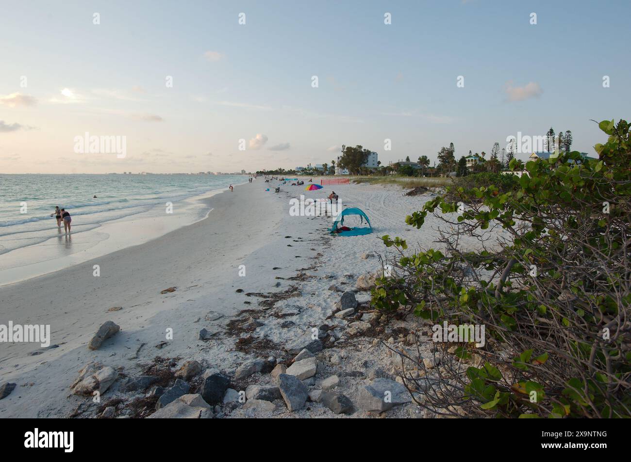Vue grand angle de la plage Pass-a-grille dans le complexe Pete Beach Florida vers le nord. Rochers et de multiples personnes marchant dans le sable et dans l'eau, près de set Banque D'Images
