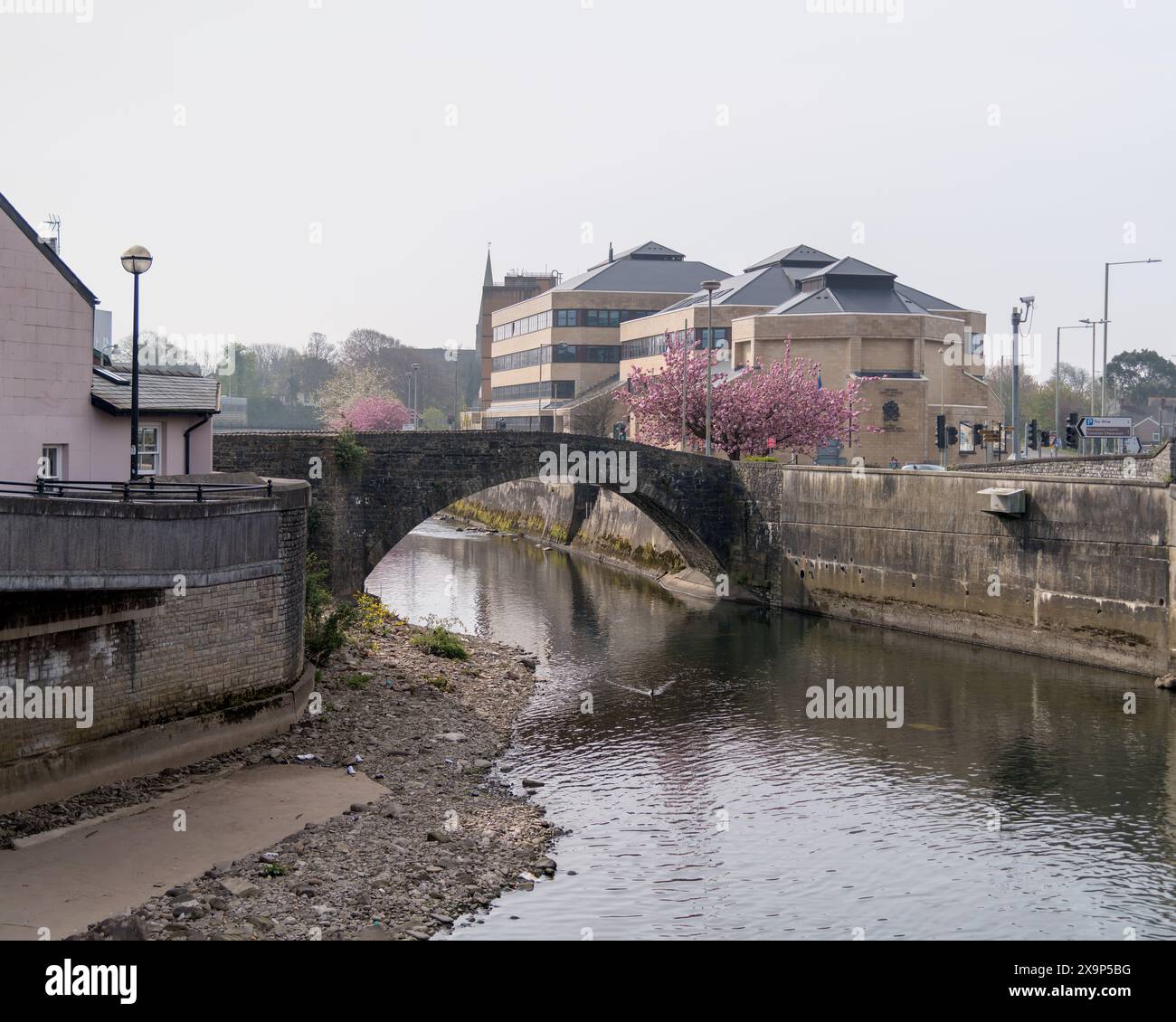 Pont médiéval à double arc de Bridgend sur la rivière Ogwr. Il a été construit vers 1425. Derrière elle se trouvent les bâtiments de la Couronne sur Angel Street. Banque D'Images