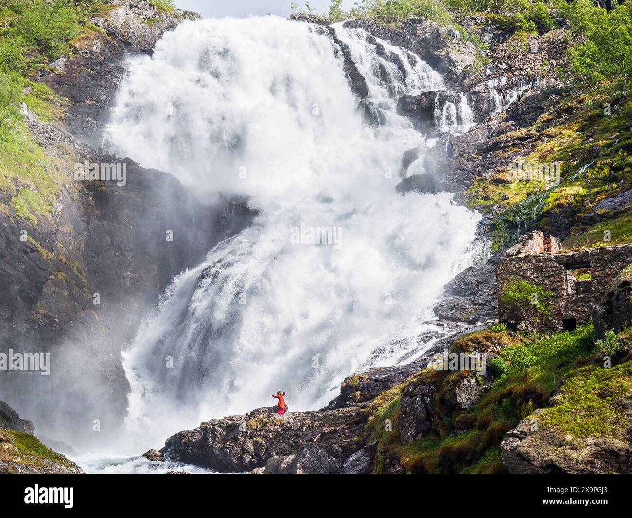 Femme dansant devant la cascade de Kjosfossen en Norvège Banque D'Images