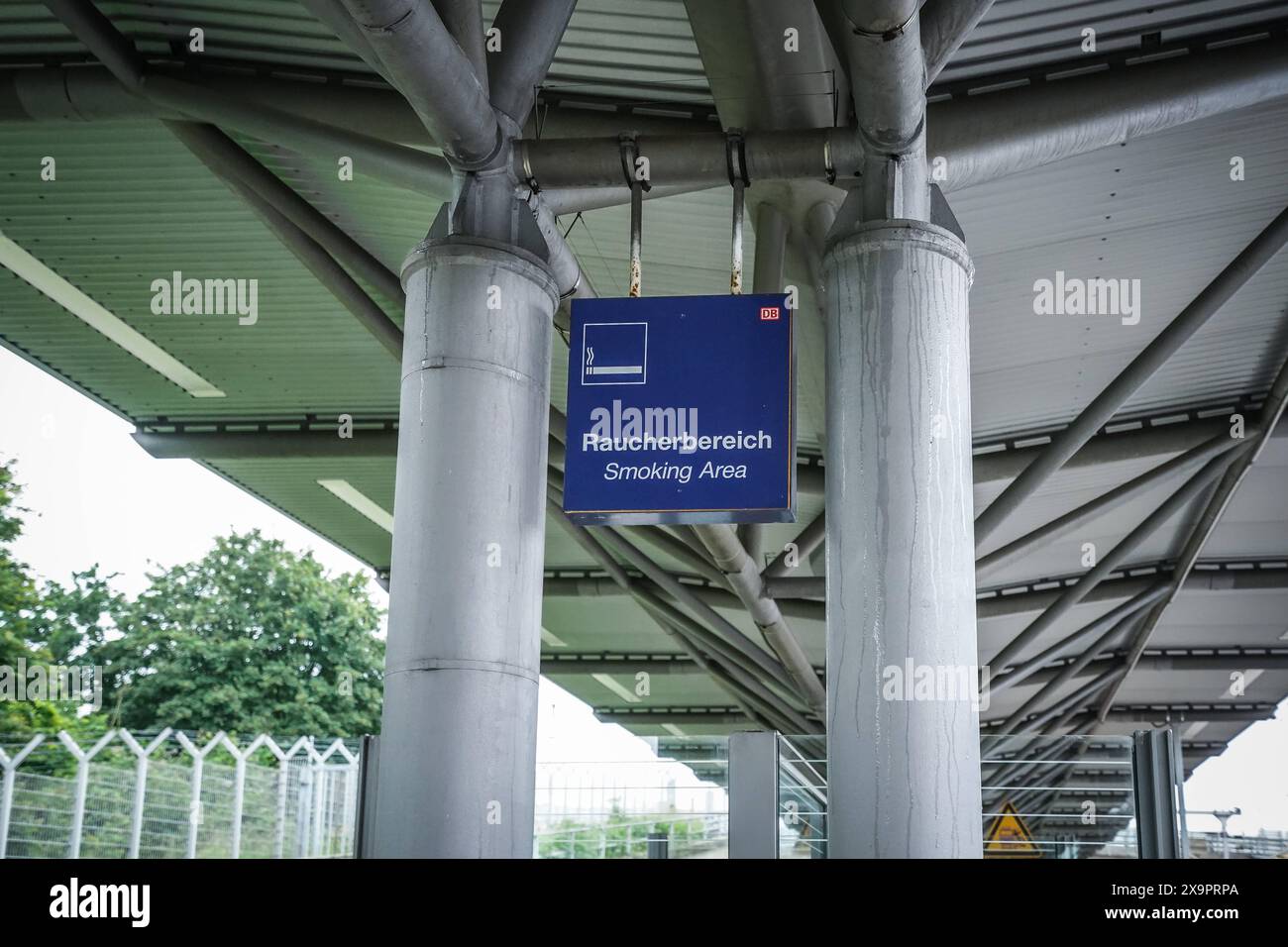 Raucherbereich, zone fumeurs, Schild, Bahnhof, überdacht, Pfeiler, Deutsche Bahn, blaues Schild, weiße Schrift, Symbol, öffentliche Einrichtung, Raucherzone, Raucher, Wartebereich, Außenbereich, Infrastruktur, modérateur Bau, Metallstruktur, Schutz vor Regen, Zigaretten, Rauchverbot außerhalb, gekennzeichneter Bereich, Bahnreisende, Raucherpause, transport, Verkehrsknotenpunkt, Deutschland - Symbolbild *** zone fumeurs, zone fumeurs, panneau, station, couvert, pilier, Deutsche Bahn, signe bleu, lettrage blanc, symbole, installation publique, zone fumeurs, fumeurs, salle d'attente, espace extérieur, infrastructure Banque D'Images