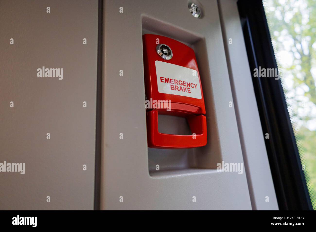La poignée rouge a une étiquette blanche qui indique sortie de secours. Il se rapporte à l'éclairage automobile, aux véhicules à moteur, au gaz, au bâtiment et aux polices, entre autres Banque D'Images
