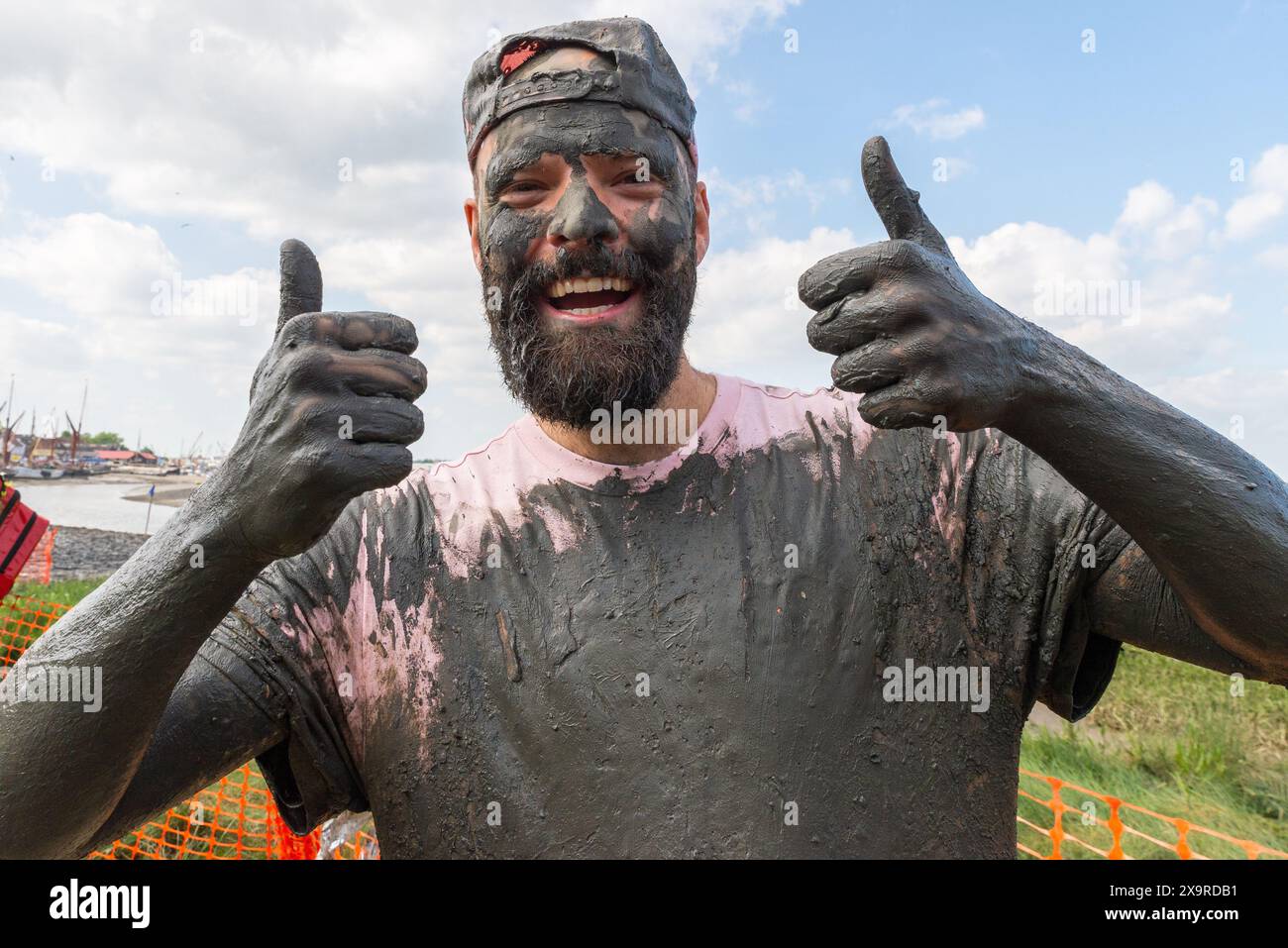 Personne couverte de boue après avoir participé à la course de boue de Maldon à Maldon, Essex, Royaume-Uni, dans la boue de la rivière Chelmer. Événement caritatif traditionnel. Banque D'Images