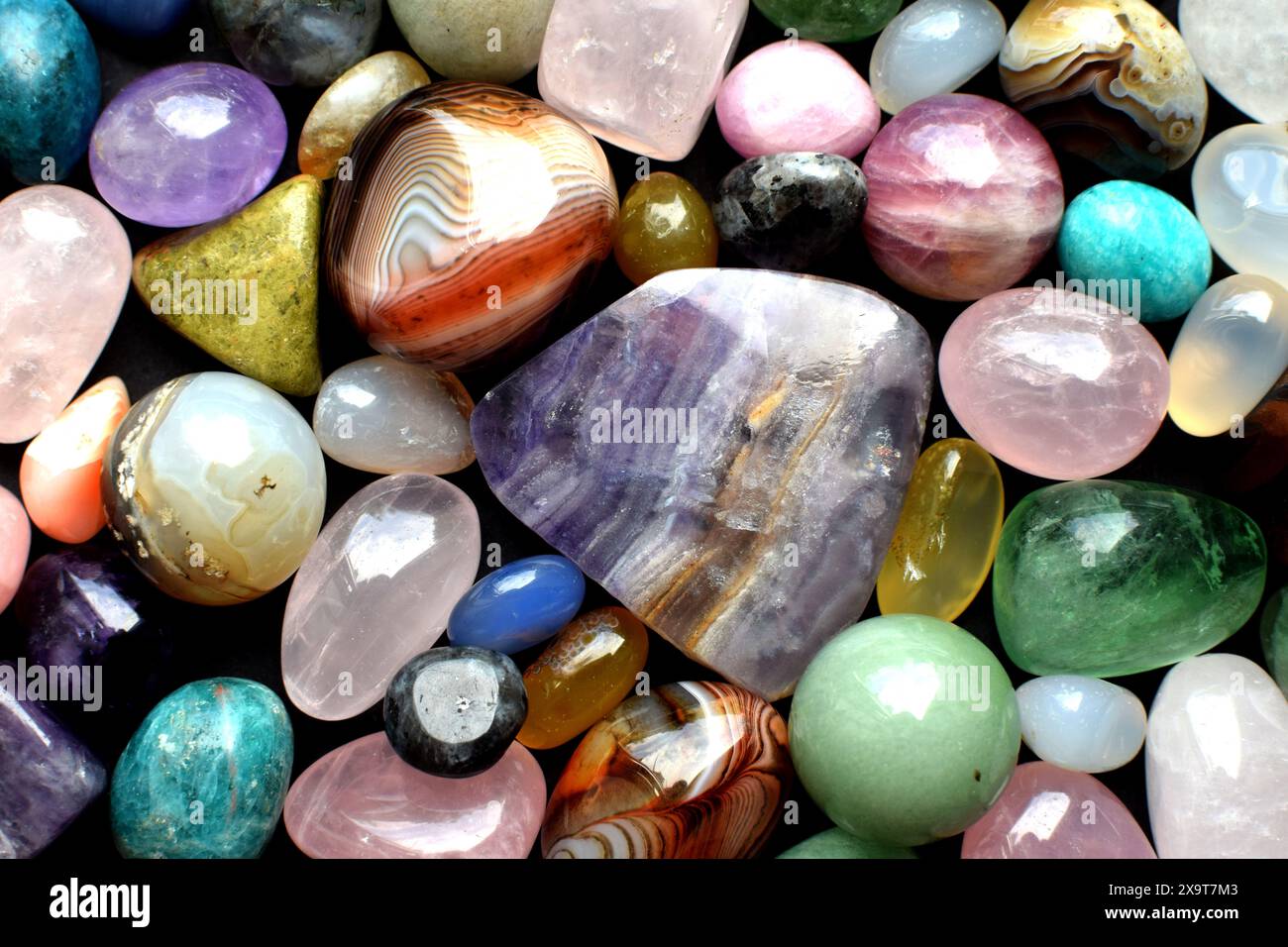 Fond fait de belles pierres semi-précieuses de couleur naturelle. Gros plan sur la fluorite violette, le quartz rose et l'agate. Banque D'Images