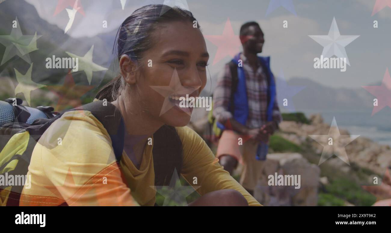 Image du drapeau américain au-dessus de couple souriant divers assis dans les montagnes Banque D'Images