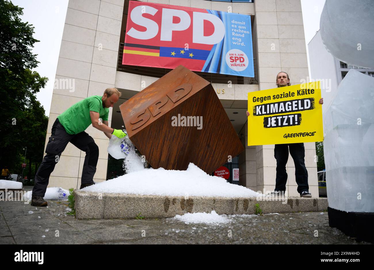 Berlin, Allemagne. 03 juin 2024. Un activiste tient une pancarte disant "contre la froideur sociale - l'argent climatique maintenant!" Lors d'une action de protestation de l'organisation de protection de l'environnement Greenpeace devant le siège du SPD. Les militants de Greenpeace ont versé environ une tonne de glace devant le siège du SPD à Kreuzberg et ont érigé un « S » gelé sur le logo du SPD pour manifester en faveur de l'introduction de l'argent pour le climat. Crédit : Bernd von Jutrczenka/dpa/Alamy Live News Banque D'Images