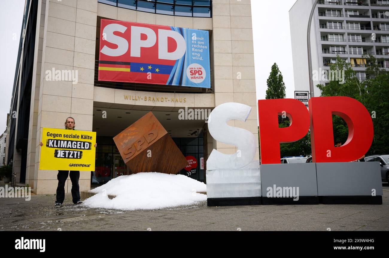 Berlin, Allemagne. 03 juin 2024. Un activiste tient une pancarte disant "contre la froideur sociale - l'argent climatique maintenant!" Lors d'une action de protestation de l'organisation de protection de l'environnement Greenpeace devant le siège du SPD. Les militants de Greenpeace ont versé environ une tonne de glace devant le siège du SPD à Kreuzberg et ont érigé un « S » gelé sur le logo du SPD pour manifester en faveur de l'introduction de l'argent pour le climat. Crédit : Bernd von Jutrczenka/dpa/Alamy Live News Banque D'Images