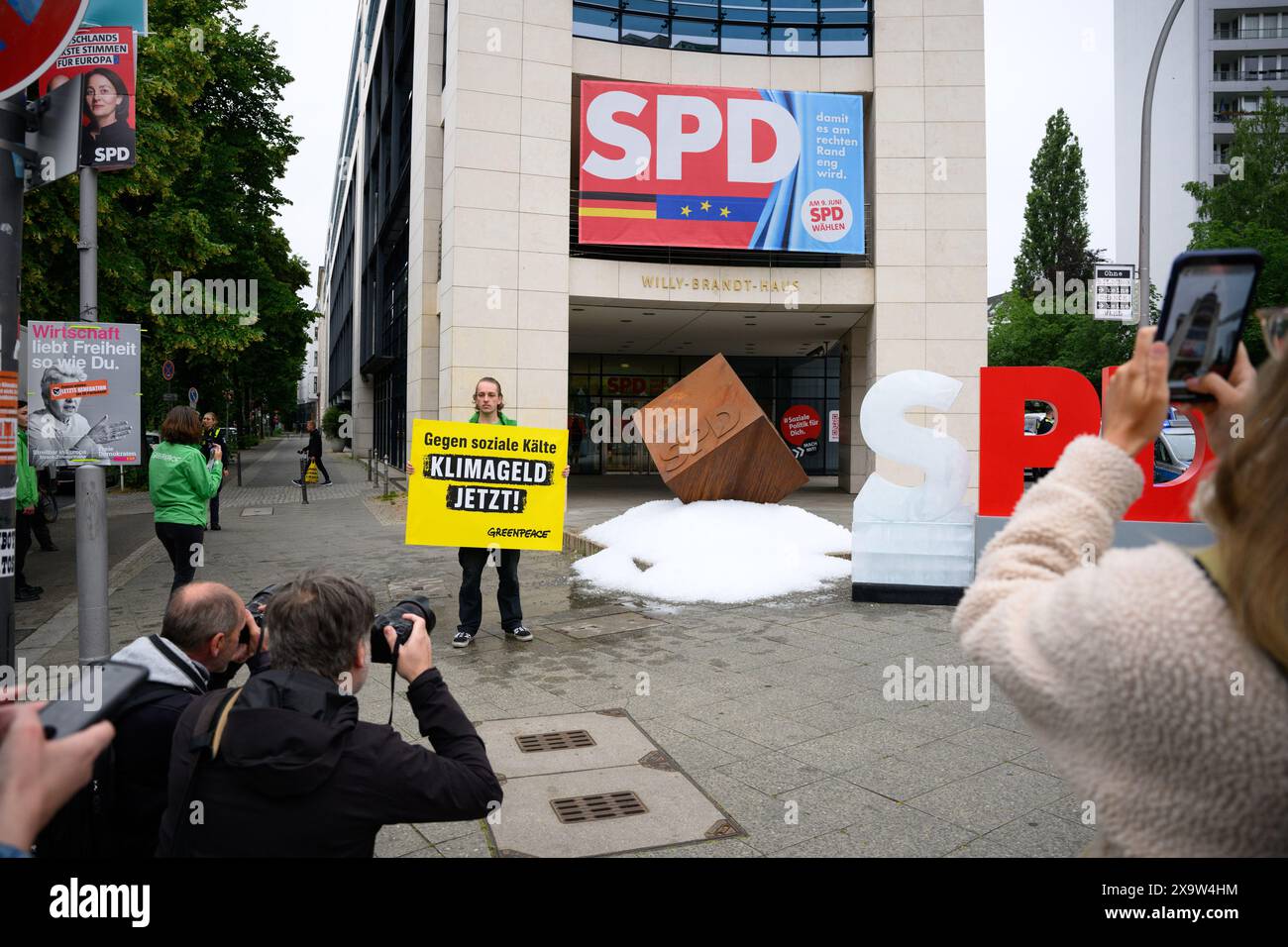 Berlin, Allemagne. 03 juin 2024. Un activiste tient une pancarte disant "contre la froideur sociale - l'argent climatique maintenant!" Lors d'une action de protestation de l'organisation de protection de l'environnement Greenpeace devant le siège du SPD. Les militants de Greenpeace ont versé environ une tonne de glace devant le siège du SPD à Kreuzberg et ont érigé un « S » gelé sur le logo du SPD pour manifester en faveur de l'introduction de l'argent pour le climat. Crédit : Bernd von Jutrczenka/dpa/Alamy Live News Banque D'Images