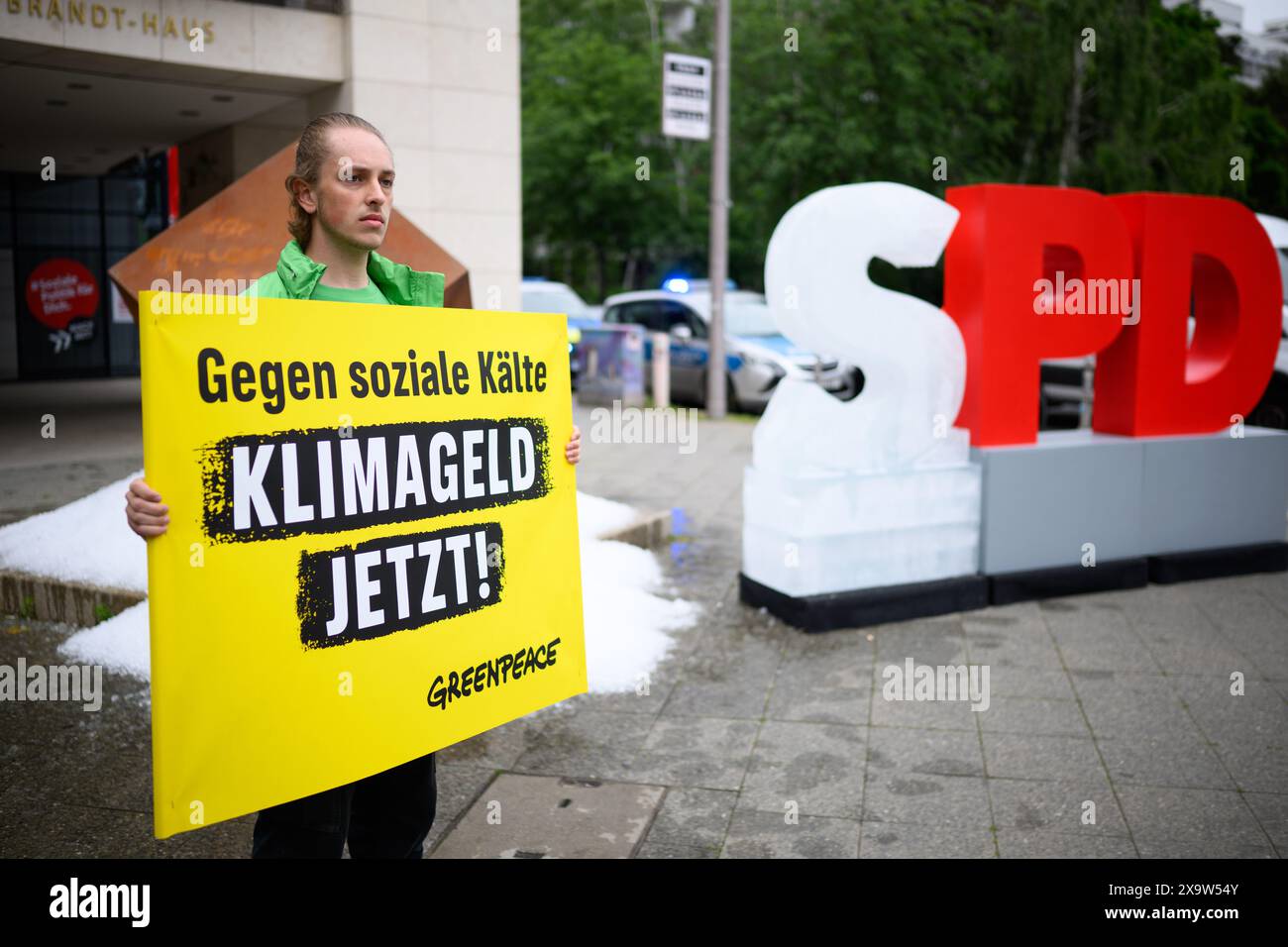 Berlin, Allemagne. 03 juin 2024. Un activiste tient une pancarte disant "contre la froideur sociale - l'argent climatique maintenant!" Lors d'une action de protestation de l'organisation de protection de l'environnement Greenpeace devant le siège du SPD. Les militants de Greenpeace ont versé environ une tonne de glace devant le siège du SPD à Kreuzberg et ont érigé un « S » gelé sur le logo du SPD pour manifester en faveur de l'introduction de l'argent pour le climat. Crédit : Bernd von Jutrczenka/dpa/Alamy Live News Banque D'Images