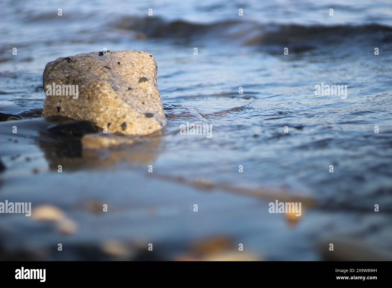 Découvrez la tranquillité avec notre superbe escapade côtière. Les vagues douces embrassent les rochers ensoleillés, créant un mélange parfait de sérénité et de beauté naturelle. Banque D'Images