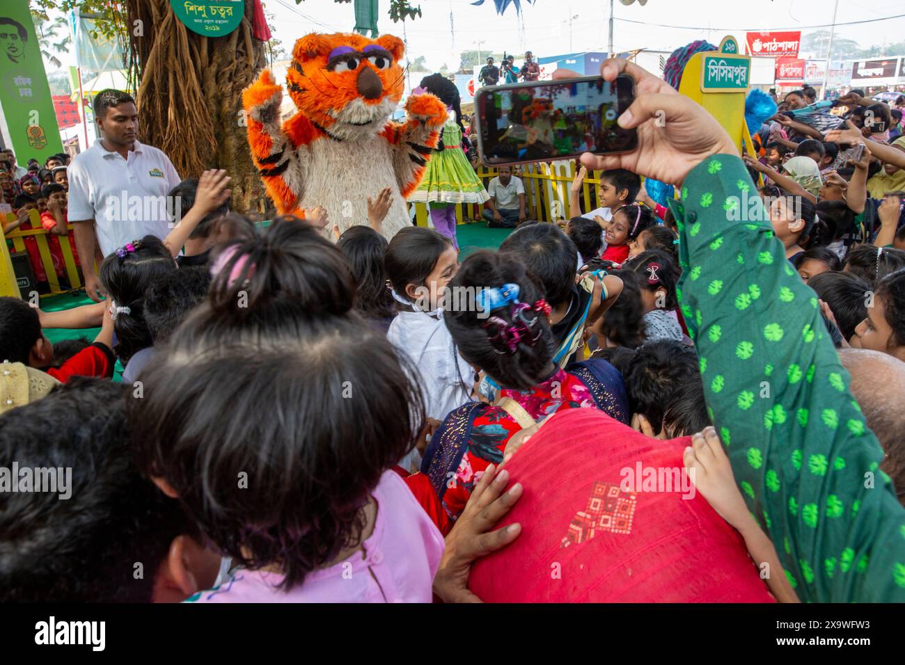 Des centaines d'enfants acclamés ont joué avec Halum, Ikri, Tuktuki et Shiku, personnages de la populaire série télévisée Sisimpur, et ont acheté leurs livres préférés A. Banque D'Images