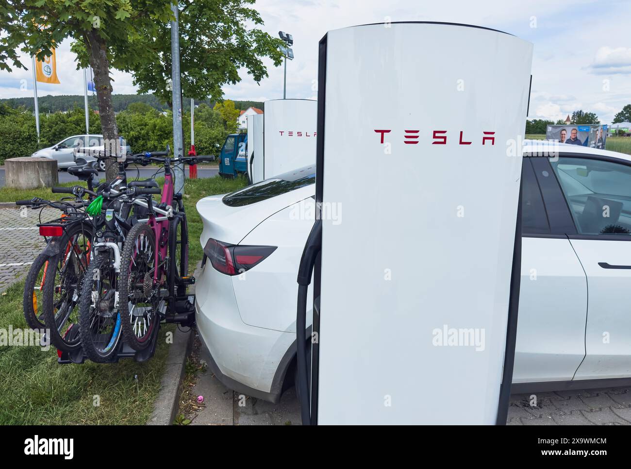 Voiture électrique Tesla avec porte-vélos sur l'attelage de remorque à une centrale électrique Tesla Super charger dans une station-service d'arrêt d'autoroute à Schwabach, Allemagne, le 27 mai 2024. Photographe : ddp images / STAR-images Banque D'Images