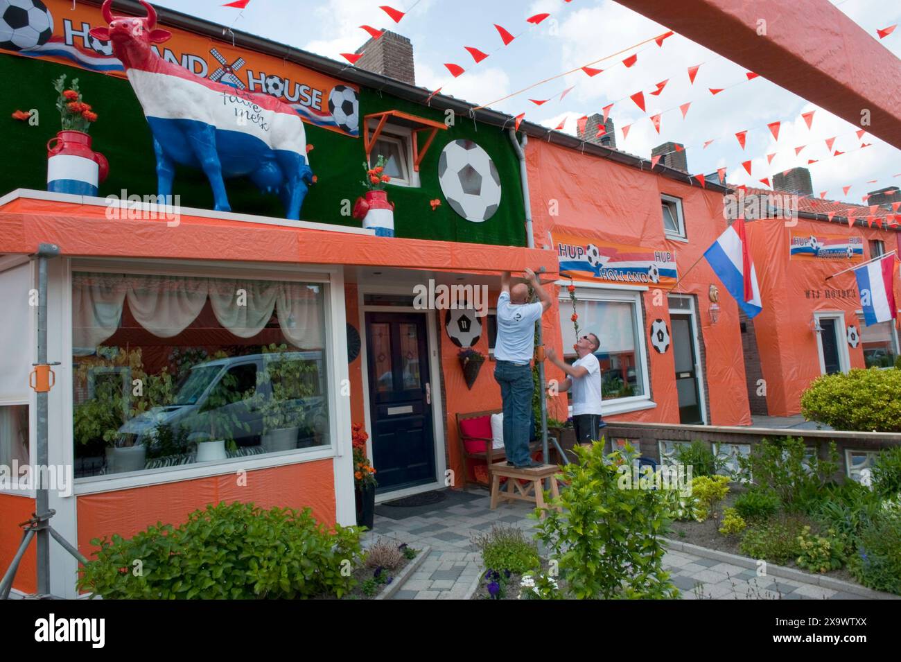 Championnat de football néerlandais Matness dans le Goirlese Irenestraat, tout le quartier a enveloppé toute la rue de couleurs orange en raison des championnats du monde de football / football. Les façades sont couvertes, un grand écran de télévision est en construction et des drapeaux et des bannières sont suspendus. Gorle, pays-Bas. Goirle Irenestraat Noord-Brabant Nederland Copyright : xGuidoxKoppesxPhotox Banque D'Images