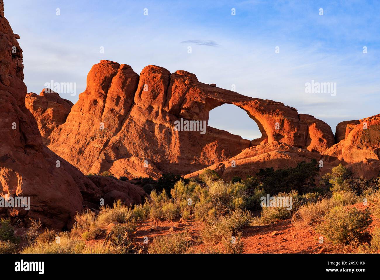 Le soleil couchant illumine Skyline Arch dans la zone Devils Garden du parc national d'Arches, Moab, Grand County, Utah, États-Unis. Banque D'Images