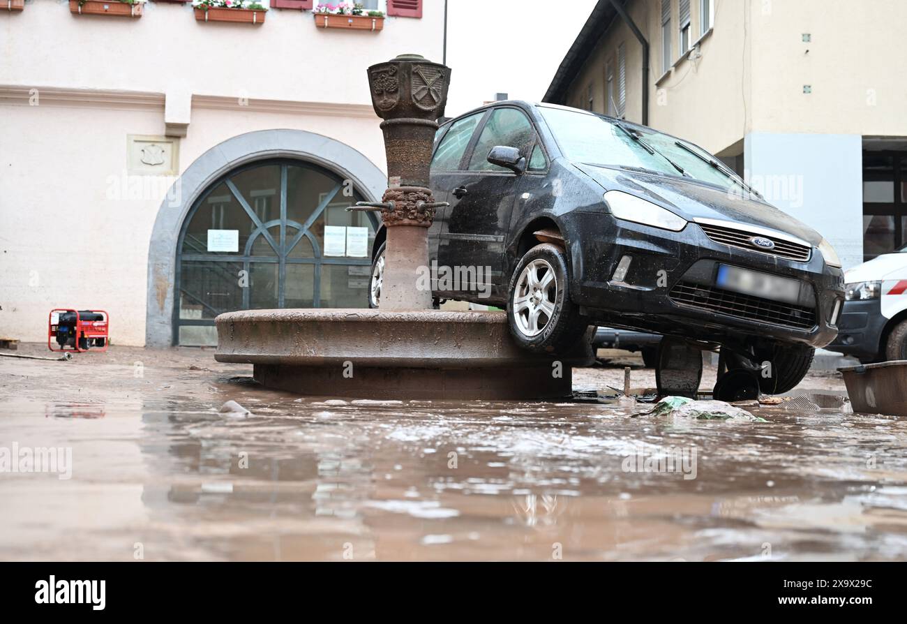 Rudersberg, Allemagne. 03 juin 2024. Une voiture emportée par les eaux de crue se dresse sur un puits à Rudersberg. Depuis des jours, les aides en Bavière et dans le Bade-Württemberg luttent contre les inondations et leurs conséquences. La situation des inondations reste dynamique et déroutante. De nombreuses petites communautés sont touchées et, dans certains endroits, la situation s'aggrave même. Crédit : Bernd Weißbrod/dpa - ATTENTION : les plaques d'immatriculation des véhicules endommagés ont été pixelisées pour des raisons légales/dpa/Alamy Live News Banque D'Images