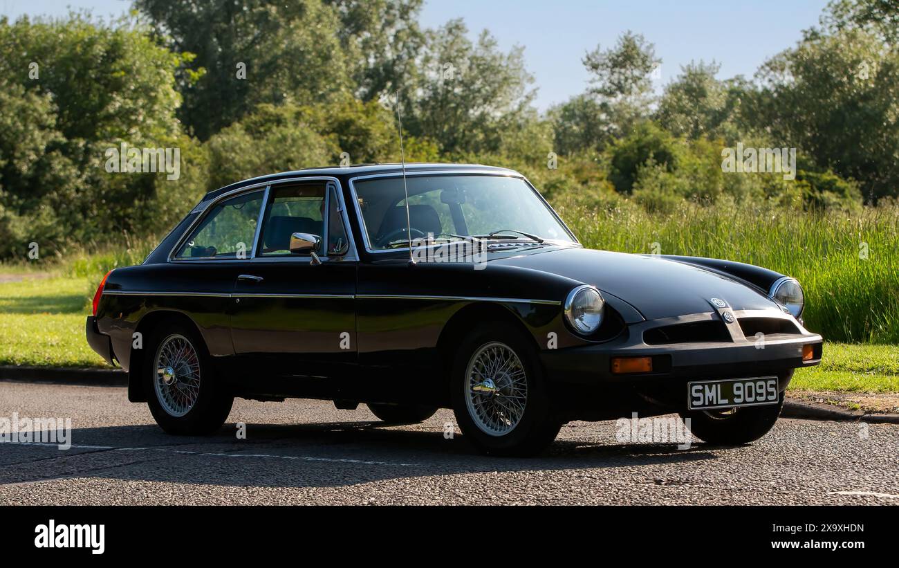 Stony Stratford, Royaume-Uni - 2 juin 2024 : 1977 noir MGB GT voiture classique conduite sur une route de campagne britannique Banque D'Images