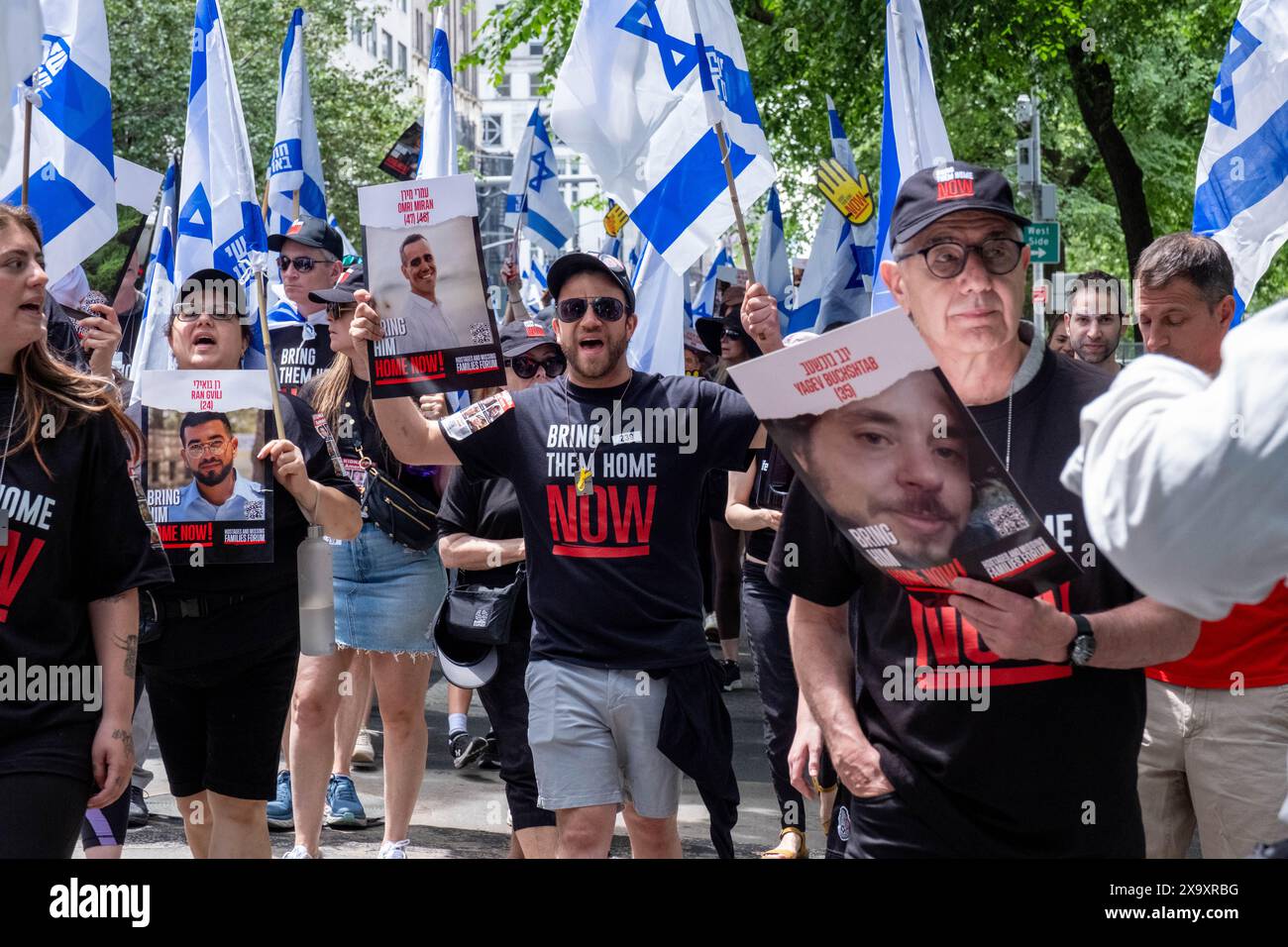 New York, États-Unis. 02 juin 2024. Les gens portant des chemises Bring Them Home défilent avec des affiches d'otages et des drapeaux israéliens. La 59e parade annuelle de la Journée d'Israël marche sur la 5e Avenue le long de Central Park. Le défilé célèbre la culture et la fierté israéliennes. Le défilé a pris un ton sombre cette année au milieu de la guerre Israël-Hamas, avec pour objectif principal de ramener chez eux les 120 otages restants encore à Gaza qui ont été enlevés le 7 octobre 2023. Crédit : SOPA images Limited/Alamy Live News Banque D'Images