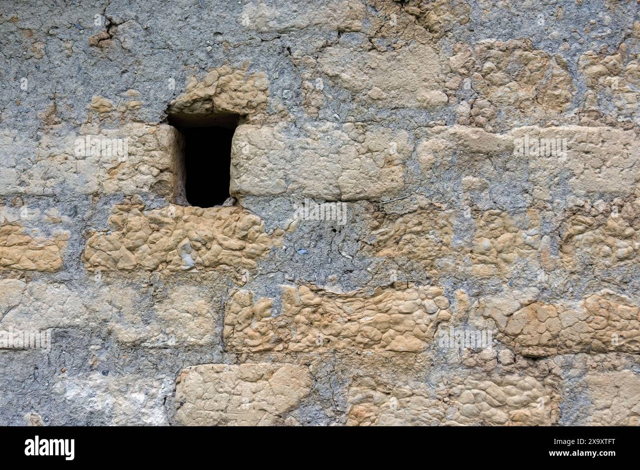 Un petit trou utilisé comme fenêtre dans un ancien hangar en adobe, dans une ferme dans les montagnes andines orientales du centre de la Colombie. Banque D'Images