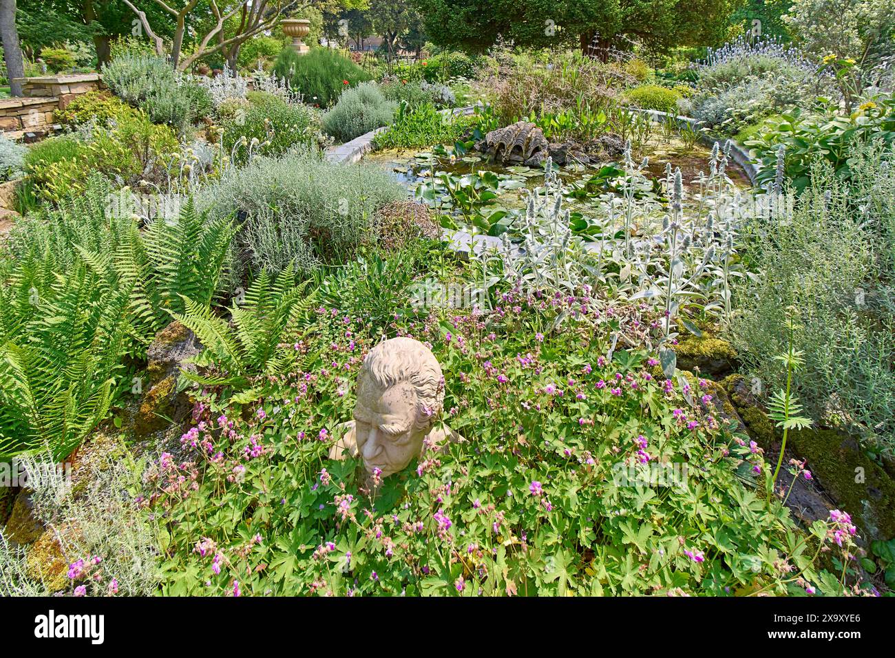 Chelsea Physic Garden une sculpture l'étang et une grande variété de plantes au printemps Banque D'Images