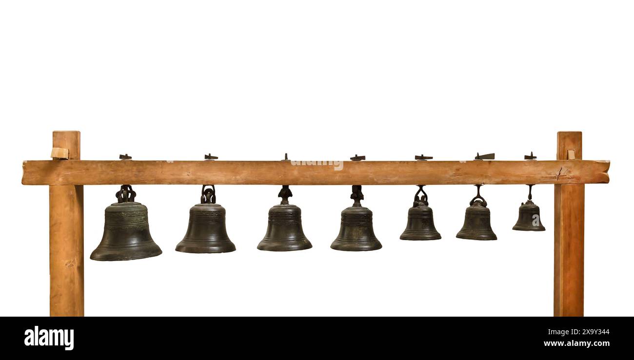 Ensemble de cloches d'église suspendues de différentes tailles sur un cadre en bois isolé sur un fond blanc Banque D'Images