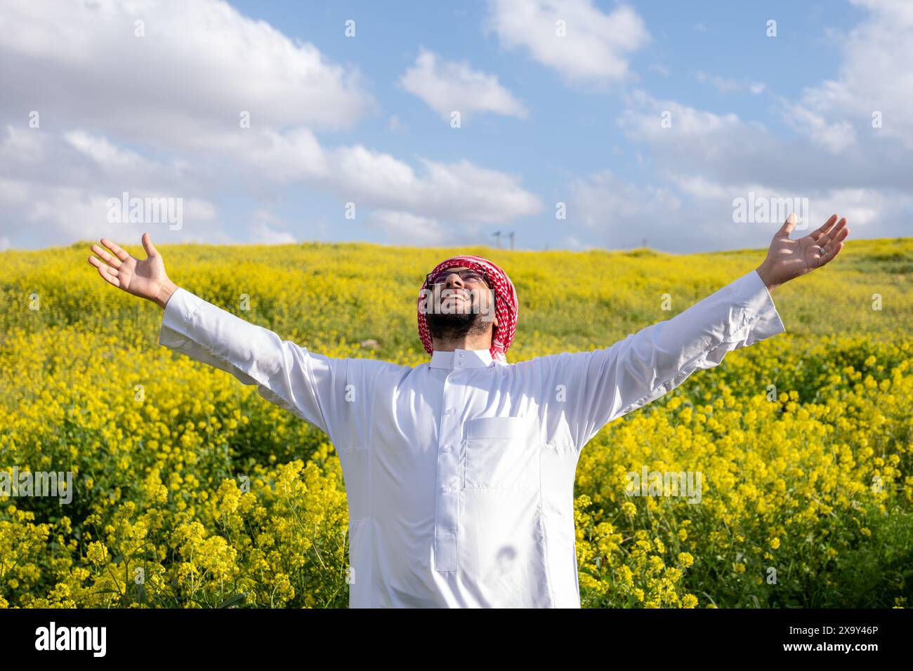 Mâle arabe profiter d'un mode de vie sain dans la nature entre les fleurs jaunes dans le champ ayant l'air frais au printemps Banque D'Images