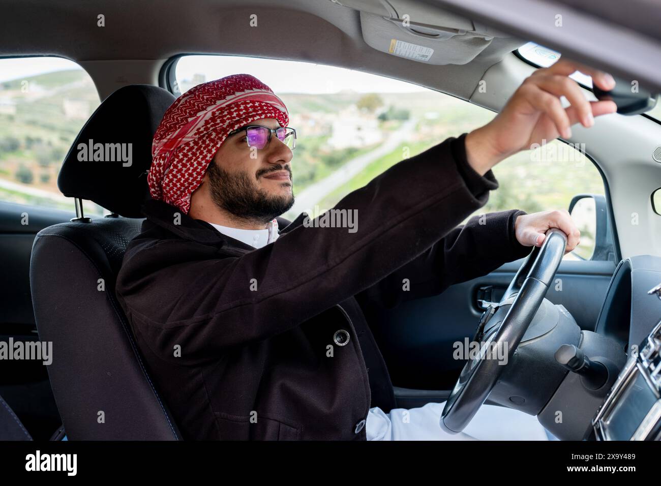 Chauffeur arabe joyeux dans sa voiture Banque D'Images