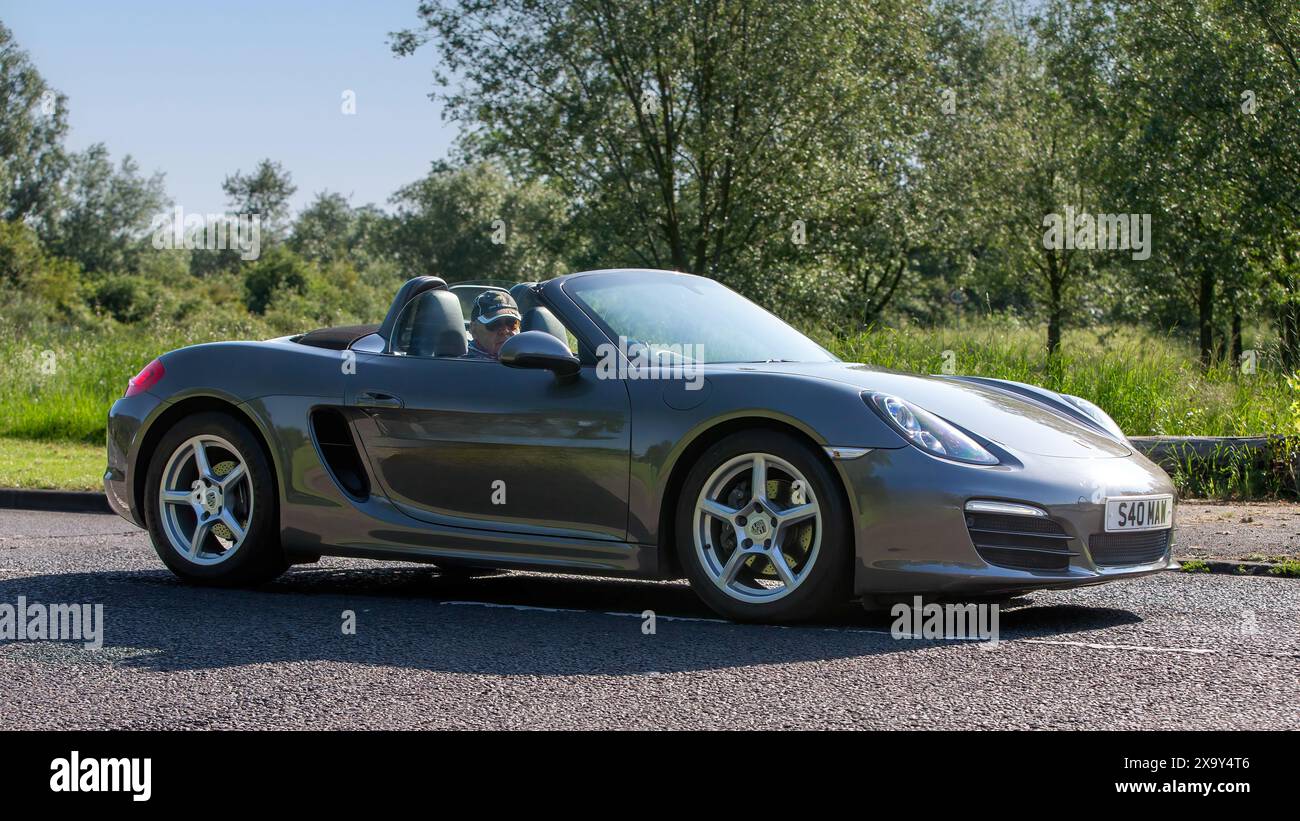 Stony Stratford, Royaume-Uni - 2 juin 2024 : 2013 gris Porsche Boxster voiture classique conduisant sur une route de campagne britannique Banque D'Images