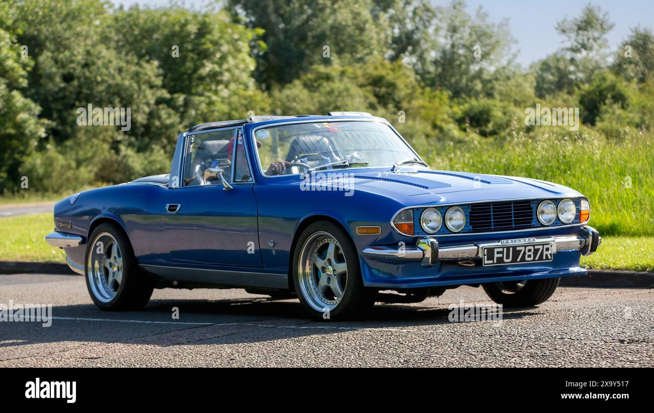 Stony Stratford, Royaume-Uni - 2 juin 2024 : 1976 bleu Triumph Stag voiture britannique classique conduisant sur une route de campagne britannique Banque D'Images