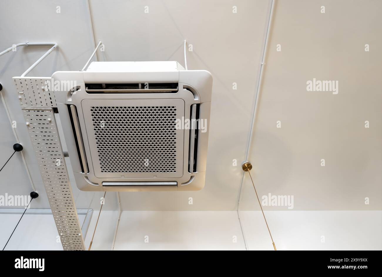Décoration de climatiseur de type cassette montée au plafond près des canalisations de fil de la lampe moderne sur le bâtiment blanc avec espace de copie. Type de plafond de climatisation Banque D'Images