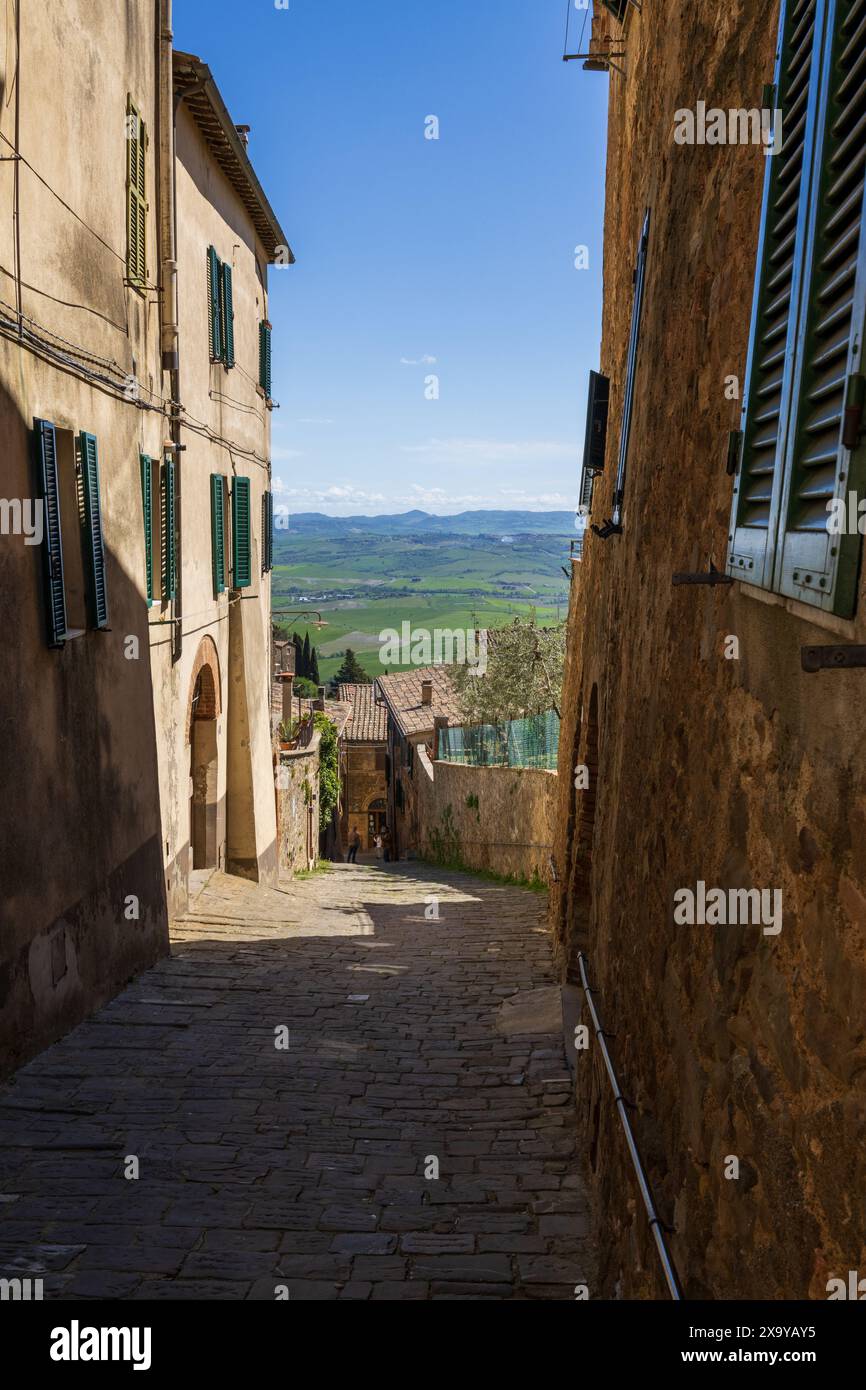 Une belle scène de rue avec des bâtiments traditionnels et pas de gens dans la ville médiévale historique de Montalcino en Toscane, Italie par une journée ensoleillée. Banque D'Images