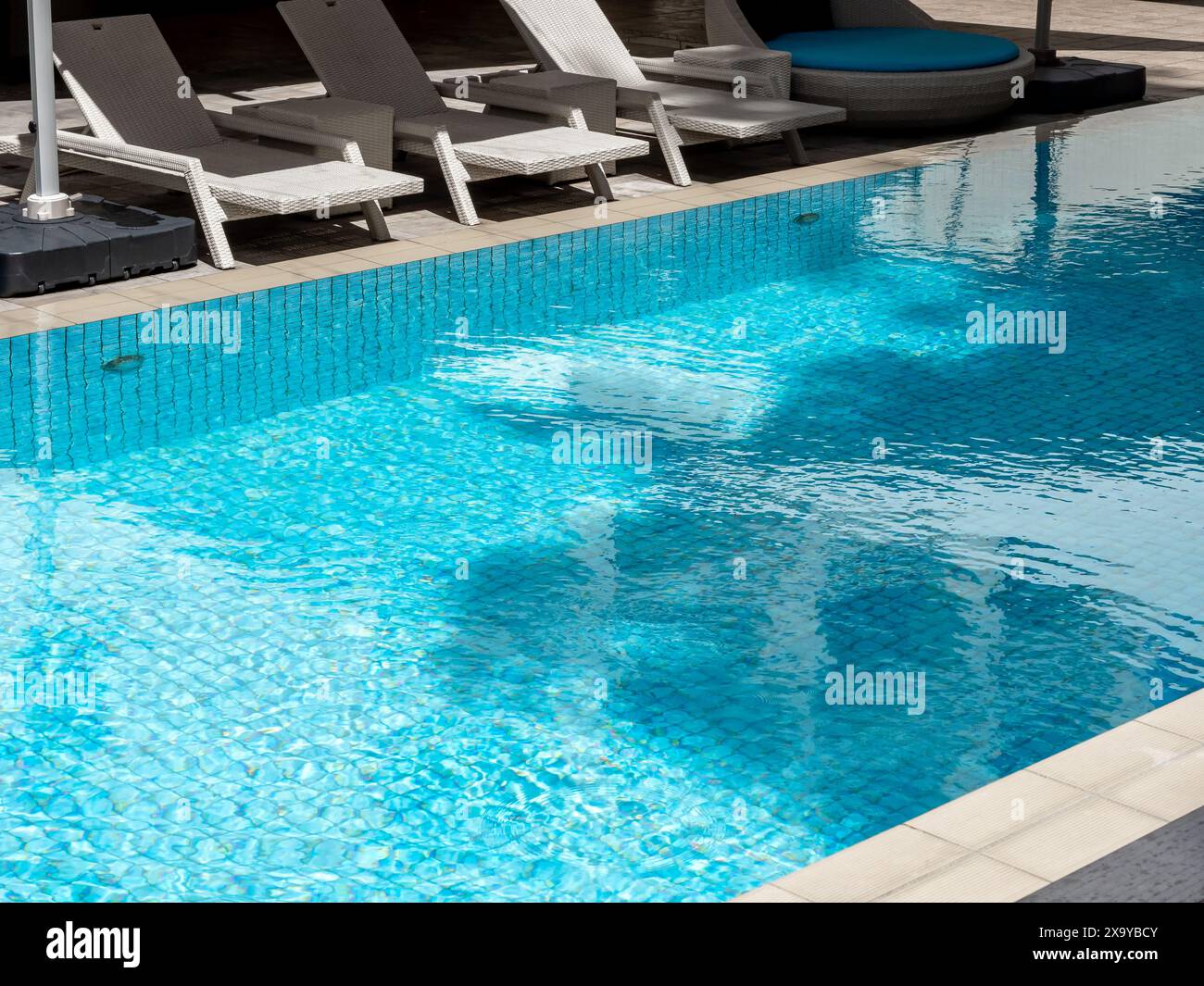 Chaise vide de chaises longues en rotin blanc moderne pour les clients près de la grande piscine extérieure dans l'hôtel Resort avec personne. Vue sur la piscine en été détente b Banque D'Images