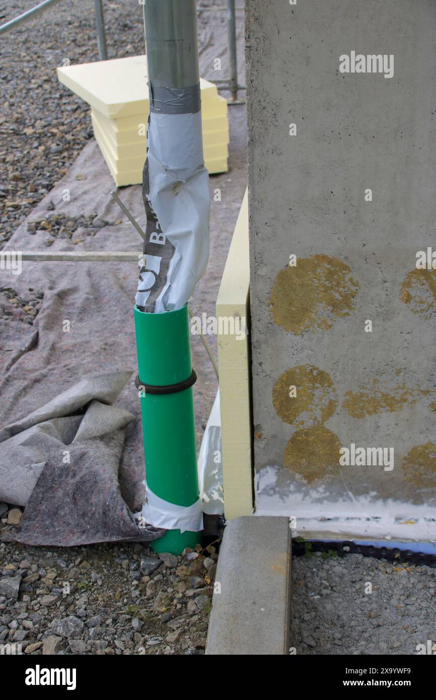 L'eau provenant d'un tuyau de descente est redirigée à l'aide d'un tuyau Banque D'Images